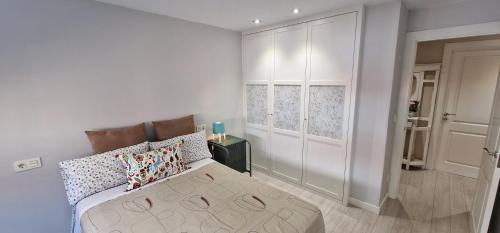 een slaapkamer met een bed en een kamer met een deur bij Tu Refugio Calmar - Pisazo céntrico 2 Hab y 2 Baños in Gijón