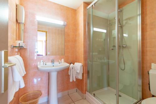 a bathroom with a sink and a shower at Hôtel Beau Site in Malbuisson
