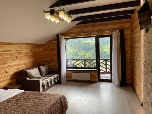 1 dormitorio con cama y ventana grande en Panorama, en Slavske