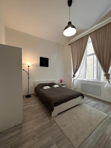 a bedroom with a bed and a large window at Dolce Vita House in Budapest