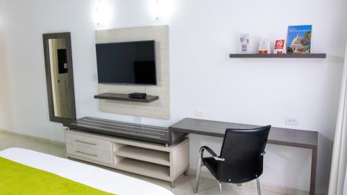 a room with a desk with a television and a chair at Hotel San Juan Internacional in Bucaramanga