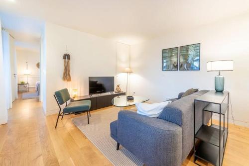 a living room with a blue couch and a table at GuestReady - Conde das Alcáçovas in Paço de Arcos
