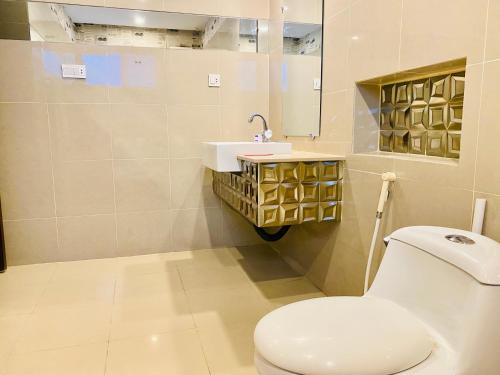 a bathroom with a toilet and a sink at HOTEL ROYAL ONE in Multan