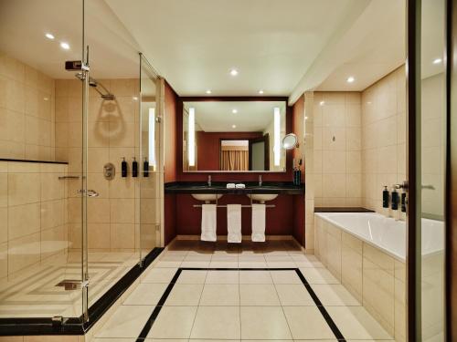 a bathroom with a shower and a tub and a sink at Hilton Warsaw City Hotel in Warsaw