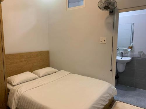Dormitorio pequeño con cama y lavamanos en Dang Nguyen Guesthouse, en Da Lat