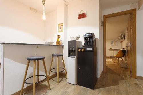 a kitchen with a bar and two stools at Pensión Úbeda in Fuenmayor