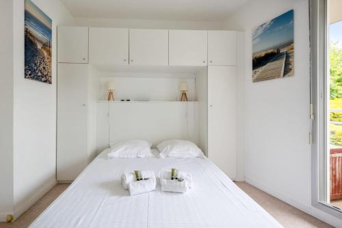 Habitación blanca con cama y ventana en Beachfront studio in Arcachon - Welkeys, en Arcachon