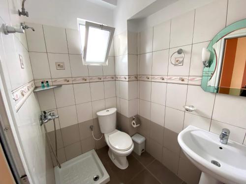 a bathroom with a toilet and a sink at Tomi Apartments in Sarandë