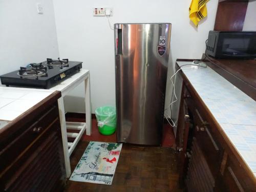 a kitchen with a stainless steel refrigerator and a stove at Gia Apartment in Shanzu