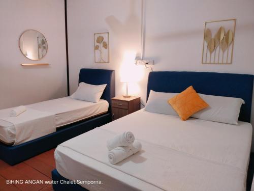 um quarto de hotel com duas camas e um espelho em BIHING ANGAN water chalet em Semporna