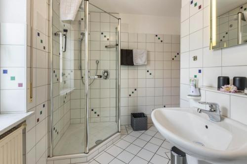 a bathroom with a glass shower and a sink at Griesbaum in Tengen