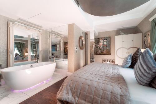 um quarto grande com uma cama grande e uma banheira em Karma Sanctum Soho Hotel em Londres