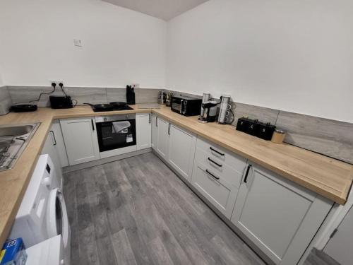 a kitchen with white cabinets and a counter top at 3 Bed House, free parking. Great for work crews - Stay Sleep Rest in Nottingham