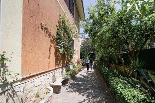 dos personas caminando por una acera al lado de un edificio en Los Mochileros Hostel - Age Limit 18-28 en Nápoles