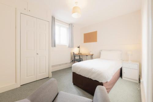 a bedroom with a bed and a desk and two chairs at West Dean College in West Dean