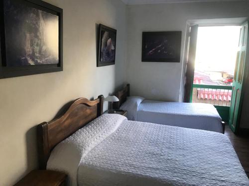 a bedroom with two beds and a window with a view at Hotel Colonial - Salamina Caldas in Salamina