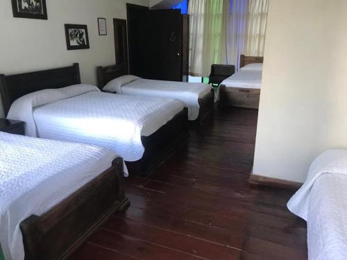 a group of four beds in a room at Hotel Colonial - Salamina Caldas in Salamina