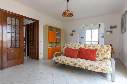 a living room with a couch with two red pillows at Vacanze Simius in Villasimius
