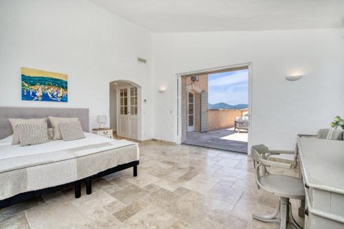 - une chambre avec un lit et une porte donnant sur une terrasse dans l'établissement Beautiful Provençal Mas in the Golfe de Saint-Tropez, à Cogolin