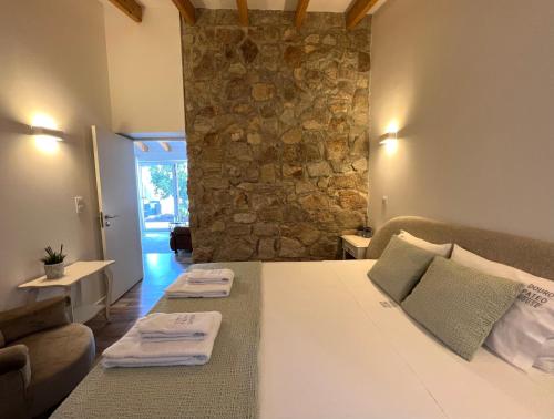 a bedroom with a bed and a stone wall at Douro Pateo House in Vila Nova de Gaia
