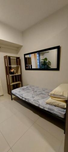 um quarto com uma cama e um espelho na parede em 2 Bedroom with Balcony/ Family Room em Manila