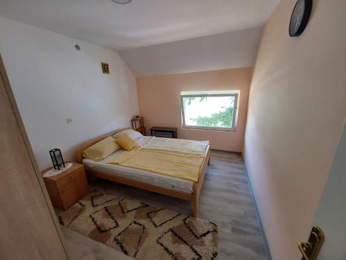 a small bedroom with a bed and a window at Dušanov Zaliv - Perućac in Skelani