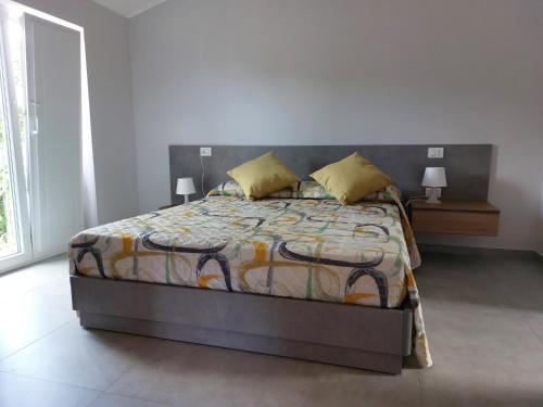 1 dormitorio con 1 cama, 2 lámparas y ventana en Casetta San Marciano Pile en LʼAquila