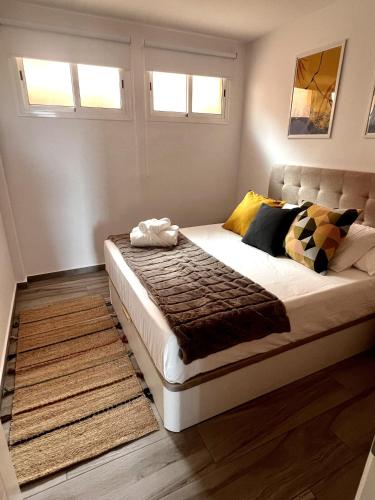 - une chambre avec un grand lit dans une pièce dotée de fenêtres dans l'établissement Bluebell L6, à Armeñime