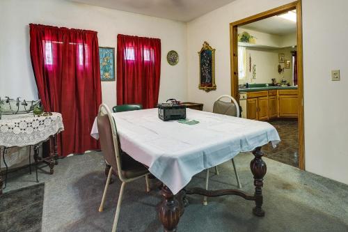 Zimmer mit einem Tisch und roten Vorhängen in der Unterkunft Remote Pet-Friendly Harlingen House! in Harlingen