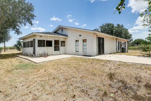 an old white house with a yard at Screened Porch Remote Harlingen House! in Harlingen