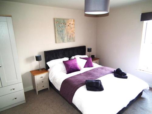 a bedroom with two beds with purple pillows at North Sea View Apartment in Scarborough