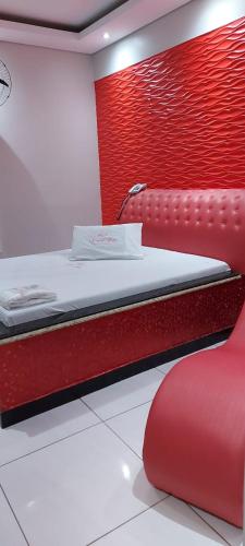 a bedroom with a bed and a red wall at VIA RECANTO in Brasilia