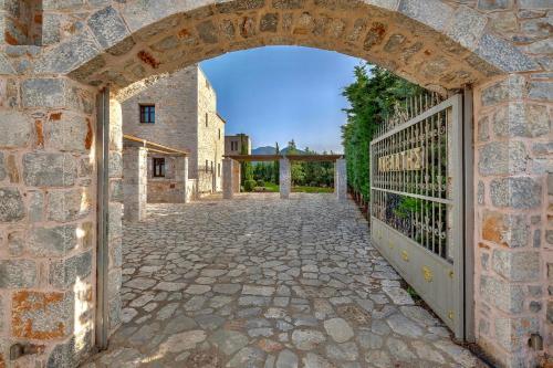 una entrada a un edificio de piedra con una puerta en Achelatis Traditional Guest Houses en Areopolis