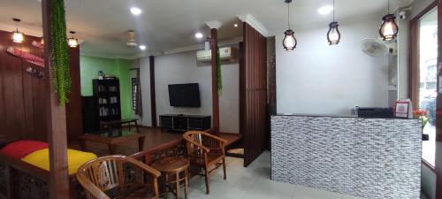un soggiorno con tavolo, sedie e TV di Hotel Harbour Stay a Malacca