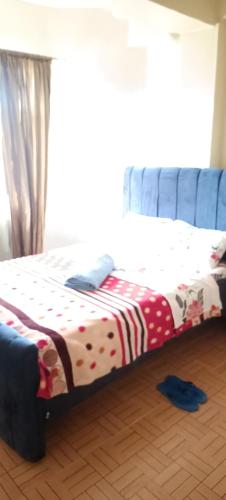 ein Bett auf einem Holzboden in einem Zimmer in der Unterkunft Akira Safaris Furnished Apartment in Migori