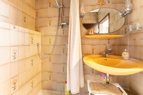 Ferienwohnung 2 في دامب: حمام مع مغسلة صفراء ومرآة