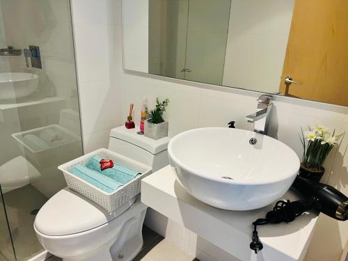 a bathroom with a sink and a toilet and a mirror at Apartamento piso 41 VIP Hermosa vista en Bogotá in Bogotá