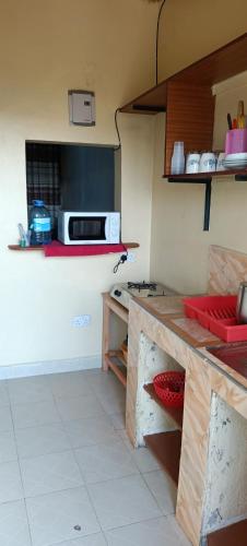 a kitchen with a stove and a counter top at Akira Safaris Furnished Apartment in Migori