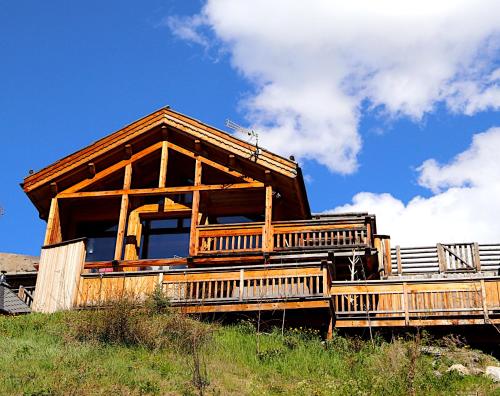 une grande cabane en bois au sommet d'une colline dans l'établissement Chalet with Ski Slope Views, Jacuzzi & Cinema Room, à Vars