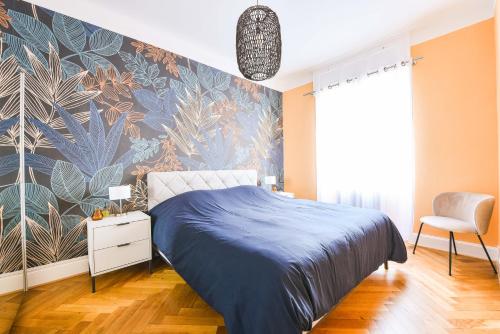 - une chambre avec un lit bleu et un mur fleuri dans l'établissement Appartement chaleureux Orangerie, à Strasbourg