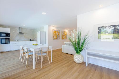 a kitchen and living room with a table and chairs at Casa D'Areia a 1 km da Praia. in Vila Praia de Âncora