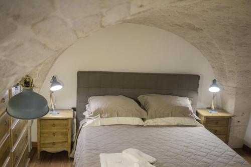 una camera da letto con un letto con due comodini e due lampade di Le Dimore del Casalvecchio a Conversano
