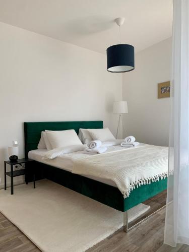 a bed with a green headboard in a bedroom at Ap-art-mán 08 in Mikulov