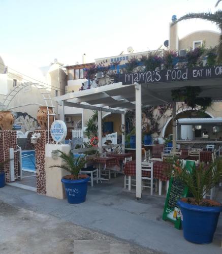 a restaurant with tables and chairs under a canopy at Villa Markos in Perissa