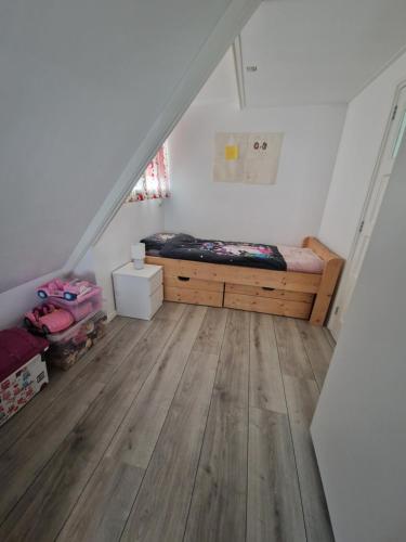 1 dormitorio con 1 cama y suelo de madera en Sfeervol huis nabij het centrum van Harlingen, en Harlingen