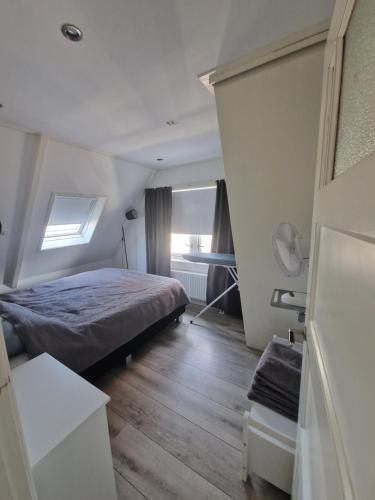 een kleine slaapkamer met een bed en een raam bij Sfeervol huis nabij het centrum van Harlingen in Harlingen