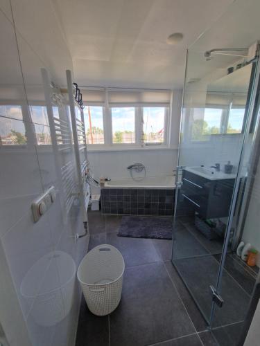 y baño con ducha y lavamanos. en Sfeervol huis nabij het centrum van Harlingen, en Harlingen