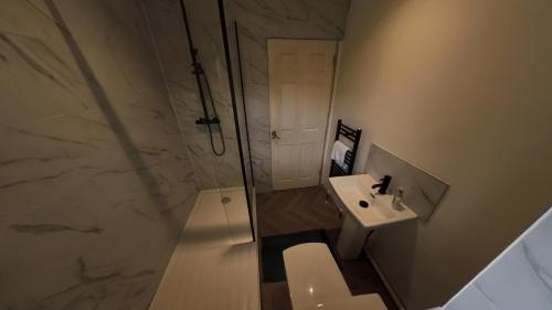 a bathroom with a shower and a toilet and a sink at Large 6 bed house - 6 Bedrooms - Parking WIFI 6 smart TVs 3 shower rooms 4 WCs in Kettering
