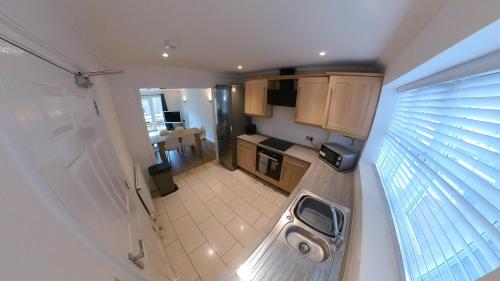 an overhead view of a kitchen with a window at Large 6 bed house - 6 Bedrooms - Parking WIFI 6 smart TVs 3 shower rooms 4 WCs in Kettering