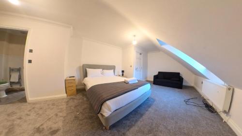1 dormitorio con cama y escalera en Large 6 bed house - 6 Bedrooms - Parking WIFI 6 smart TVs 3 shower rooms 4 WCs, en Kettering